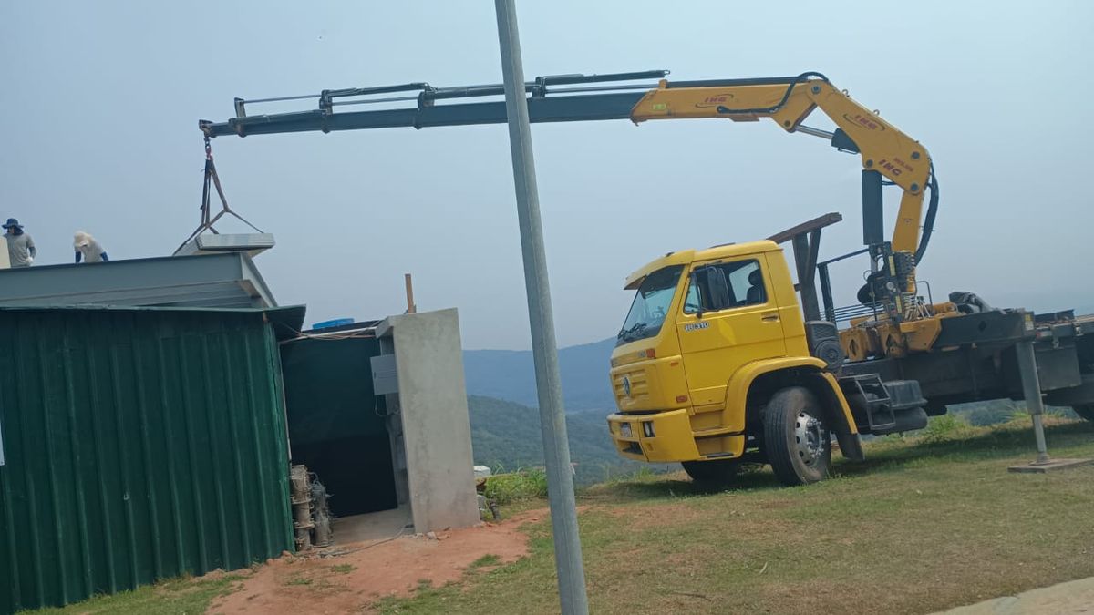 Munck içando estrutura de cobertura metálica em construção no alto de morro