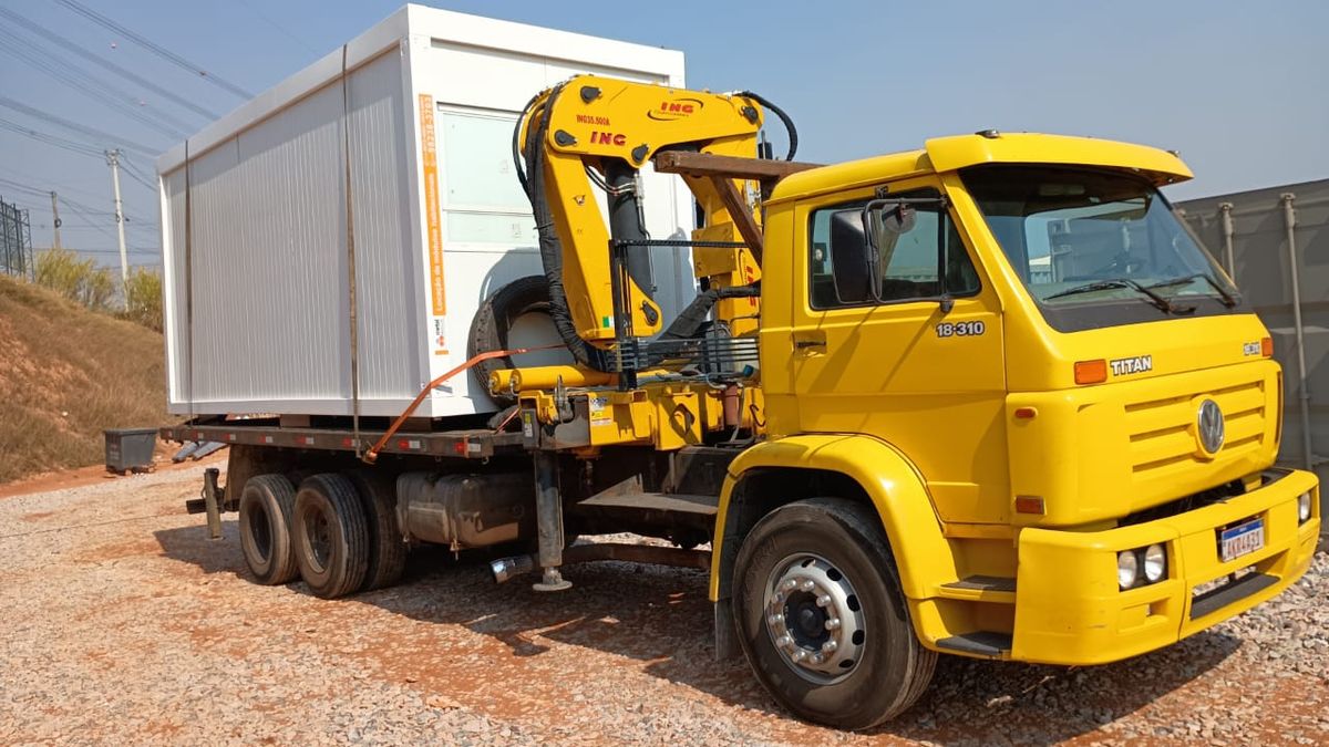 Munck amarelo Batista transportando módulo habitável branco sobre a carroceria